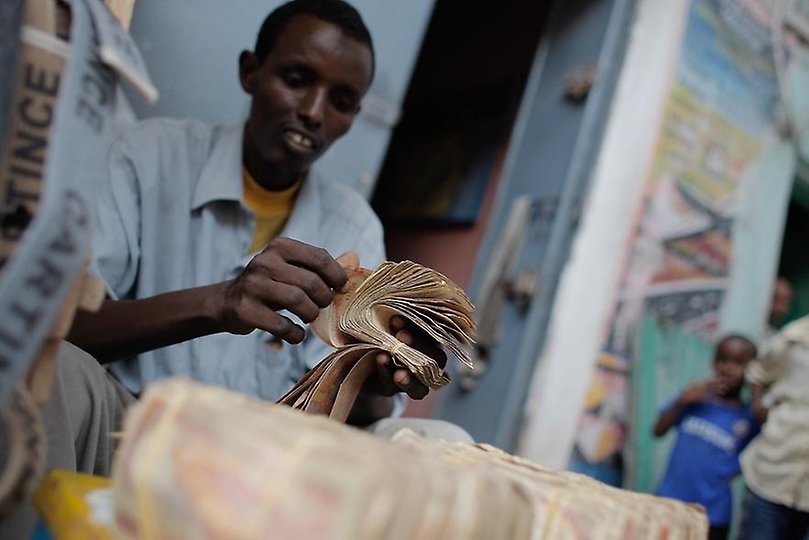 A money exchanger counts Somali shilling notes on the streets of the Somali capital Mogadishu