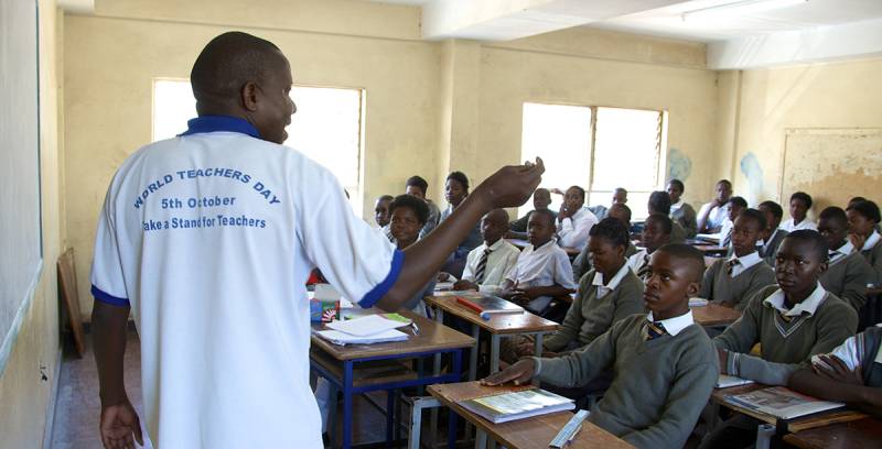 Man (teacher) in front of class of students in a classroom