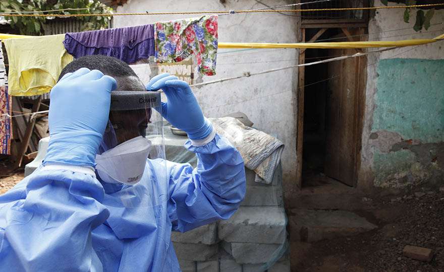 Gibriel Kabba, a swabber for the ministry of health, prepares to enter a house with protective clothing. Freetown, Sierra Leone in March, 2016.