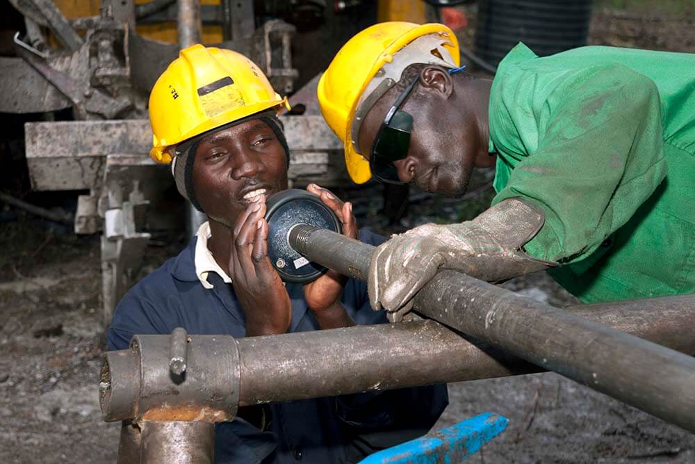 Mineral exploration drilling. Two workers orientating the core in a drill rod.