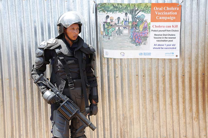 A formed police unit (FPU) woman officer from Rwanda, holding a weapon.