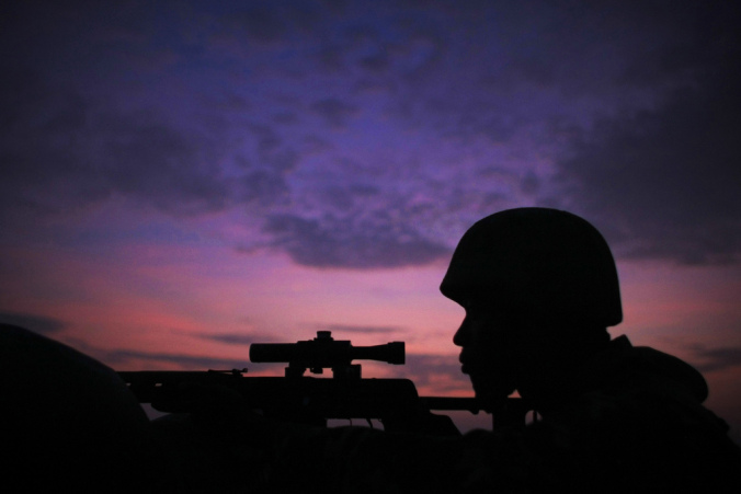 Silhouette of a soldier aiming with a rifle