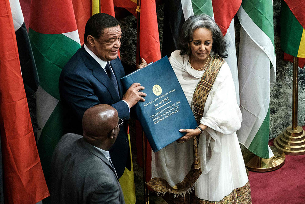 Ethiopia's first female President Sahle-Work Zewde recieves a book of the Constitution from former President Mulatu Teshomea at the Parliament in Addis Ababa on October 25, 2018