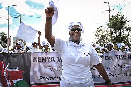 Fanis Lisiagali, Executive Director of Healthcare Assistance Kenya, leads the White Ribbon Campaign march to promote their call center hotline which responds to violence against women in elections. 