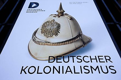 A poster for the exhibition 'German Colonialism' with a historic German spiked helmet displayed outside the German Historic Museum in Berlin. 